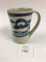 Front angled view of the Sam Uhlick pottery mug showing cobalt and chrome decoration