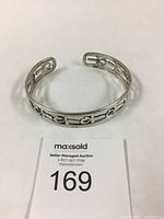 Sterling silver cuff bracelet with repeated Ankh symbols in open design, displayed from above showing open cuff shape.