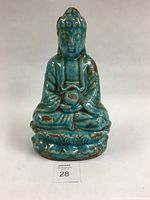 Front view of turquoise glazed terracotta Buddha statue seated meditating