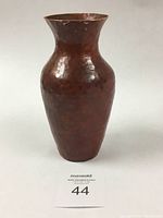 Full view of the copper vase showing rounded shape and flared top.