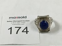 Front view of vintage sterling silver ring with oval lapis lazuli stone and rope border.