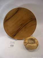 Both turned wood pieces photographed together showing the plate and the smaller vessel with glass insert