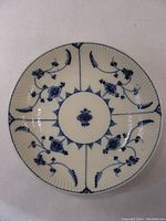 Top-down view of antique blue floral fluted dessert bowl showing detailed flower and vine design with cream background and fine fluted texture.