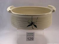 Front view of Dan Taylor oval ceramic baking dish showing dragonfly design and handles.