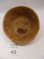 Top-down view showing the circular coiled weave pattern and the burn marks inside the basket.