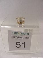 Silver ring on a clear plastic display box with sale label showing lot number 51.