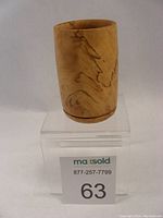 Front view of spalted maple wooden vase on clear acrylic stand with lot number card visible below.