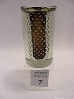 Front angled view of clear art glass vase with bubble pattern and brown inner core on base.