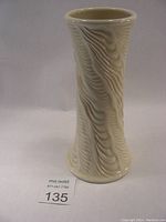 Full front view of the porcelain vase showing textured wave pattern and overall form.