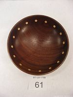 Top view of the walnut bowl showing the circular light wood inlays around the interior rim and the wood grain.