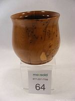 Front view of turned yew wood vase showing polished surface and wood grain.