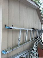 Side view of the aluminum ladder showing paint marks and blue end cap.