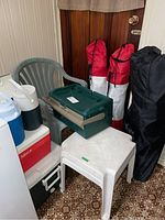 Photo showing green Old Pal tackle box, plastic coolers in red and blue, green resin chair, and folded camp chairs with red and black covers, white resin table.