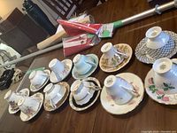 Overview of 11 assorted vintage cups and saucers on wooden table