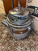 Photo of vintage Filter Queen vacuum cleaner showing wood grain sides, coiled cord, and chrome top with handle.
