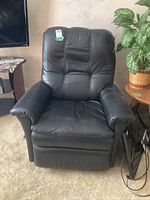 Front view of black leather recliner showing overall shape and upholstery