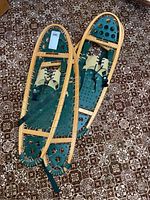 Two pairs of Winter Hiker snow shoes placed on patterned carpet showing full length and shape.
