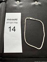 Full view of silver bracelet with clasp and no visible flaws.