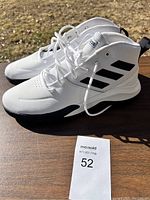 Pair of white Adidas high-top athletic shoes with black stripes, size 12, shown from side and top angles.