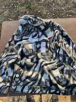 Full view of the Nike hoodie showing camo pattern and front Nike logo with tags attached.