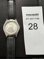 Front view of Kenneth Cole men's watch showing silver dial, two subdials, and black leather strap.