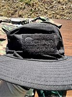 Close-up of a black tactical style hat with 'Scipio Tactical' patch on front.