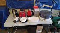 Overview of all appliances and safe on table with visible cords and accessories