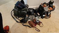 Overview of all cameras, bag, boxes, filters and flash units on carpet