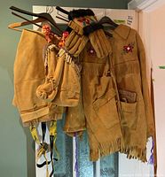 Full ensemble: coat, trousers, gloves, pouch and boots hanging on wall