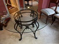 Top down view showing clear large circular glass surface and detailed metal base.