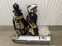 Lot contents showing two golf bags filled with clubs, container of golf balls, and practice net box.