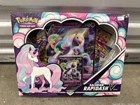 Photo of sealed Pokemon Galarian Rapidash V Box showing front art, promo card, regular card, and booster packs inside.