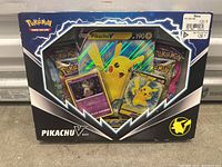 Photo of a sealed Pokemon Pikachu V box containing promo cards and multiple booster packs in original packaging.