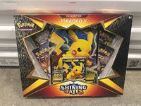 Sealed Pokemon Shining Fates Collection Pikachu V box showing front packaging with visible booster packs and promo card inside.