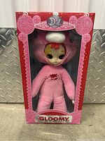 Front view of the boxed Dal Gloomy plush doll showing character in pink suit and white hat with red drips.