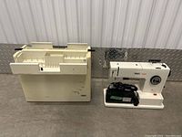 Off-white Pfaff sewing machine next to matching carrying/storage case against corrugated metal backdrop