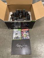 Xbox 360 Batman Arkham Origins Collector's Edition box open with diorama and items in front including game case and comic book.