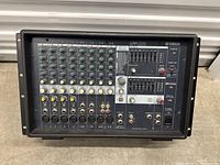 Front view of Yamaha EMX312SC powered mixer showing input channels, EQ, effects, and control knobs.