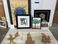 Wide shot showing the astrological chart, crayon rubbings of seated figures, framed Buddha print, tree art, and black and gold face rubbing.