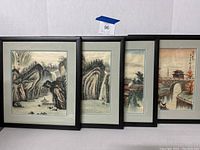 Set of 4 framed Asian silk prints leaning against a wall, showing full view of each frame and artwork
