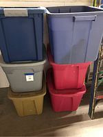 Full view of six plastic totes stacked in two columns, showing colors and sizes.