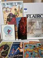 Seven posters displayed, including the Real Maestranza de Sevilla bullfighting poster, Philippines travel poster dated 1990, red chili peppers poster, Flairco artistic poster, and parts of three other posters.