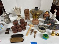 Full lot overview showing various metalware, figurines, wooden containers, and novelty items.