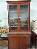 Full view of two-piece Kimball wooden bookcase with upper glass doors and lower wooden doors