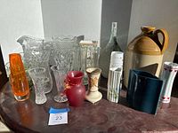 Wide view of all vases and the stoneware jug grouped on table.