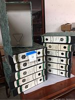 Photo showing side view of several vintage file boxes stacked horizontally and vertically, featuring spine labels and the inner metal clasp visible on one open box.