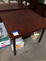 Full view of wooden folding card table showing surface and legs.