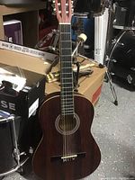 Front view of acoustic guitar showing body, fretboard, sound hole, rosette, and headstock with tuning pegs.