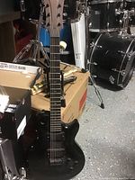 Full body view of black LAG electric guitar showing overall condition and missing control knob area.
