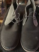Front view showing dark gray suede upper with lace-up closure and visible stitching on sole